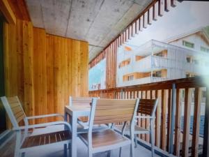 a room with two chairs and a table and stairs at Saas Grund MiK Home in Saas-Grund