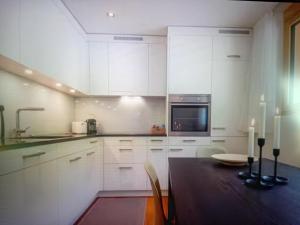 a kitchen with white cabinets and a table and a microwave at Saas Grund MiK Home in Saas-Grund