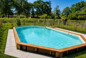 a swimming pool in a yard with a fence at Élégance et nature votre refuge entre mer et forêt in Vielle-Saint-Girons