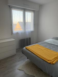 a bedroom with a bed and two windows at Langueux Apartment in Langueux