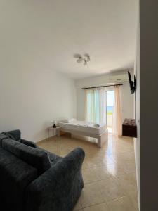 ein Wohnzimmer mit Sofa und Bett in der Unterkunft Sunset Dream Guesthouse in Himarë