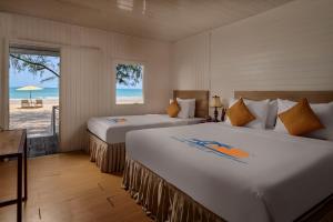 two beds in a room with a view of the beach at Sandy Beach Bungalows by EHM in Koh Rong Sanloem +76 photos