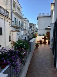 a courtyard with purple flowers and white buildings at B&B Dolce Idea in Peschici