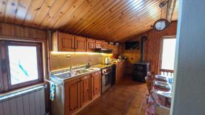 a kitchen with wooden cabinets and a sink and a stove at C'Amunin Casa Vacanze in Chiuro
