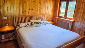 a bedroom with a bed in a wooden cabin at C'Amunin Casa Vacanze in Chiuro