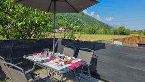 a table with chairs and an umbrella on a balcony at C'Amunin Casa Vacanze in Chiuro