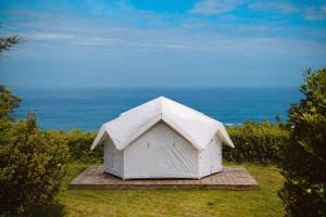 a white tent with the ocean in the background at HolaCamp Luarca in Luarca