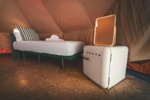 a room with a bed and a suitcase in a tent at HolaCamp Luarca in Luarca