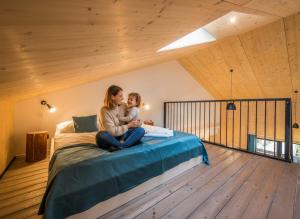 a woman and a child sitting on a bed at Demänová Rezort in Liptovský Mikuláš +236 photos