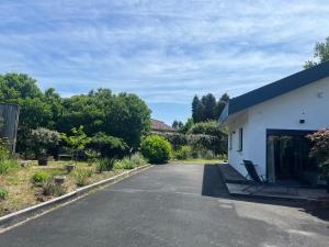 an empty parking lot next to a white building at Gîte PAPYRUS in Sainte-Eulalie-en-Born
