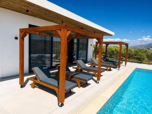 a deck with lounge chairs and a swimming pool at Antiope Retreat in Pitsidia