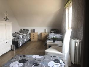 a bedroom with two beds and a table and a chair at Julie's Place in Westerlo +17 photos