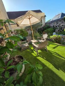 a patio with two benches and an umbrella at Il Etait Une Fois in Pierrefonds