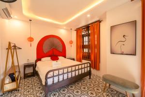 a bedroom with a bed with a red headboard at Bao An Home old Town in Hoi An