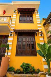 a yellow house with brown doors and windows at Bao An Home old Town in Hoi An
