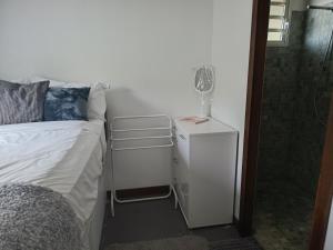 a bedroom with a bed and a glass of wine on a night stand at Studio à Tamaon - Malima Lodge in Pouembout