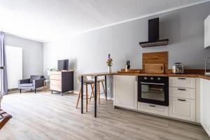 a kitchen with white cabinets and a table with chairs at stuub langenbach in Titisee-Neustadt