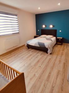 a bedroom with a bed and a wooden floor at Gîtel'harmonie2 in Fraize