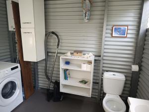 a bathroom with a toilet and a washing machine at Studio à Tamaon - Malima Lodge in Pouembout +9 photos