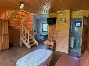 a living room with a staircase in a log cabin at Agroturystyka Jeleni Skok in Cisna