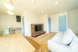 a living room with a white couch and a television at raw 白馬唯一屋上露天を独り占めできるデザインコンテナホテル in Hakuba +38 photos
