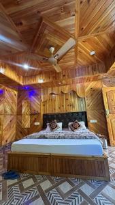 a bedroom with a bed in a wooden ceiling at Maya Homestay & Cafe in Kasol