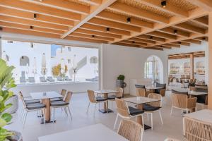 a restaurant with tables and chairs and a large window at Aegean Plaza Hotel in Kamari