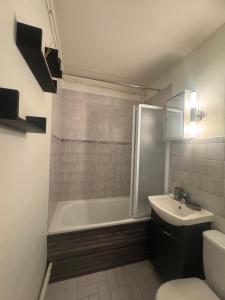 a bathroom with a tub and a sink and a toilet at Studio centre ville in Évreux
