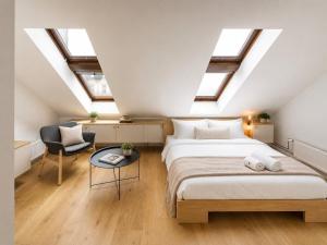 a attic bedroom with a bed and a chair at Villa Šanca in Bratislava