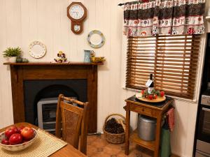 a kitchen with a fireplace and a table and a clock at Dillons Cottage in Stanthorpe +15 photos