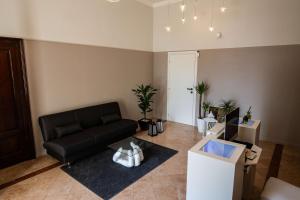 a living room with a black couch and a table at Le Dolci Dimore in Virgilio