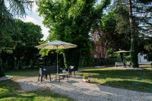 a table and chairs and an umbrella in a park at Le Dolci Dimore in Virgilio