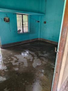 an empty room with a blue wall and a window at Pranusree Holiday Home in kolkata