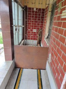 an entrance to a brick building with a metal door at Pranusree Holiday Home in kolkata