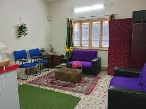 a living room with a purple couch and chairs at A2 Guest House in Salt Lake City