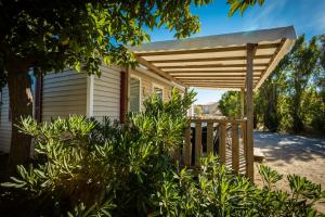 a wooden pergola in front of a house at Camping Rives des Corbières in Port Leucate