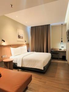 a hotel room with a bed and a desk at Samai Suites in Bandar Lampung