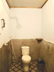 a bathroom with a white toilet in a room at Signatura Scuba Gili gede Dive and Stay in Pelangan