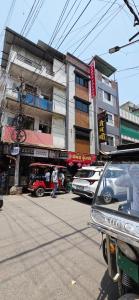 a street with cars parked in front of a building at Hotel Durga Palace in Ujjain
