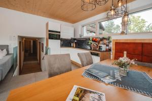 a kitchen and living room with a wooden table in a room at Appartementhaus Anna in Leogang