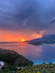 ein Sonnenuntergang über einem großen Gewässer in der Unterkunft Sunset Dream Guesthouse in Himarë