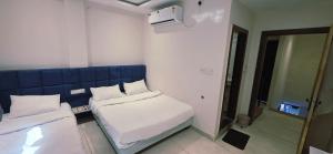 a small room with two beds and a mirror at Hotel Durga Palace in Ujjain