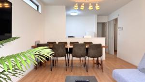 ein Esszimmer mit Tisch und Stühlen in der Unterkunft Rect YOFUKE in Nago