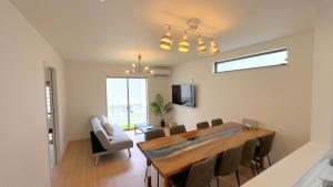 ein Esszimmer mit einem großen Holztisch und Stühlen in der Unterkunft Rect YOFUKE in Nago