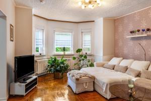 a living room with a couch and a tv at Ferienwohnung Waldglück in Lauchhammer