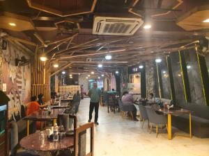 a dining room with people sitting at tables in a restaurant at Manjeet Hotel & Restaurant in Ballia +3 photos