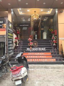 a scooter parked in front of a building with stairs at Manjeet Hotel & Restaurant in Ballia