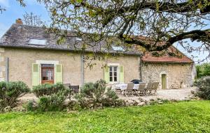 a stone house with a table and chairs in front of it at Cottage À La Campagne in Mérigny