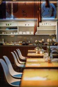 ein Restaurant mit einem langen Tisch und weißen Stühlen in der Unterkunft Grimm's Berlin Mitte in Berlin