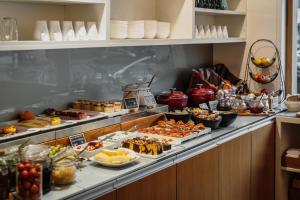 ein Buffet mit vielen verschiedenen Speisen in der Unterkunft Grimm's Berlin Mitte in Berlin + 45 Fotos